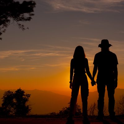 Young couple enjoying the sunset in the mountain
